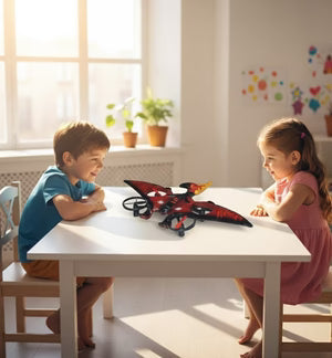 Two children playing with a red dinosaur flying toy on a white table in a bright room